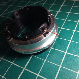 The aperture ring (the one you move to change aperture once the lens is fully assembled) was stiff, so i decided to take it apart. Remove the screw with the red arrow.