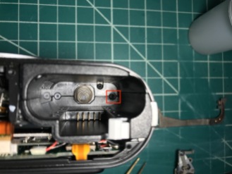 Remove only the screw closer to the side of the camera, in the battery compartment