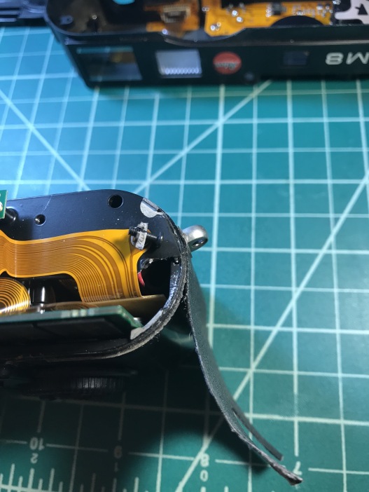 As you can see, the chassis is broken, probably because the camera was dropped at some point. That screw is the one that you have to unscrew from the bottom of the camera (see image 6). Because of this, whoever repaired the camera before, used a lot of glue to keep the top cover secured.